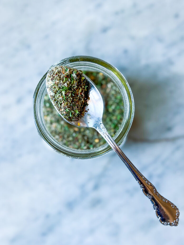 Greek Spice blend in a jar with a spoon of spice seasoning