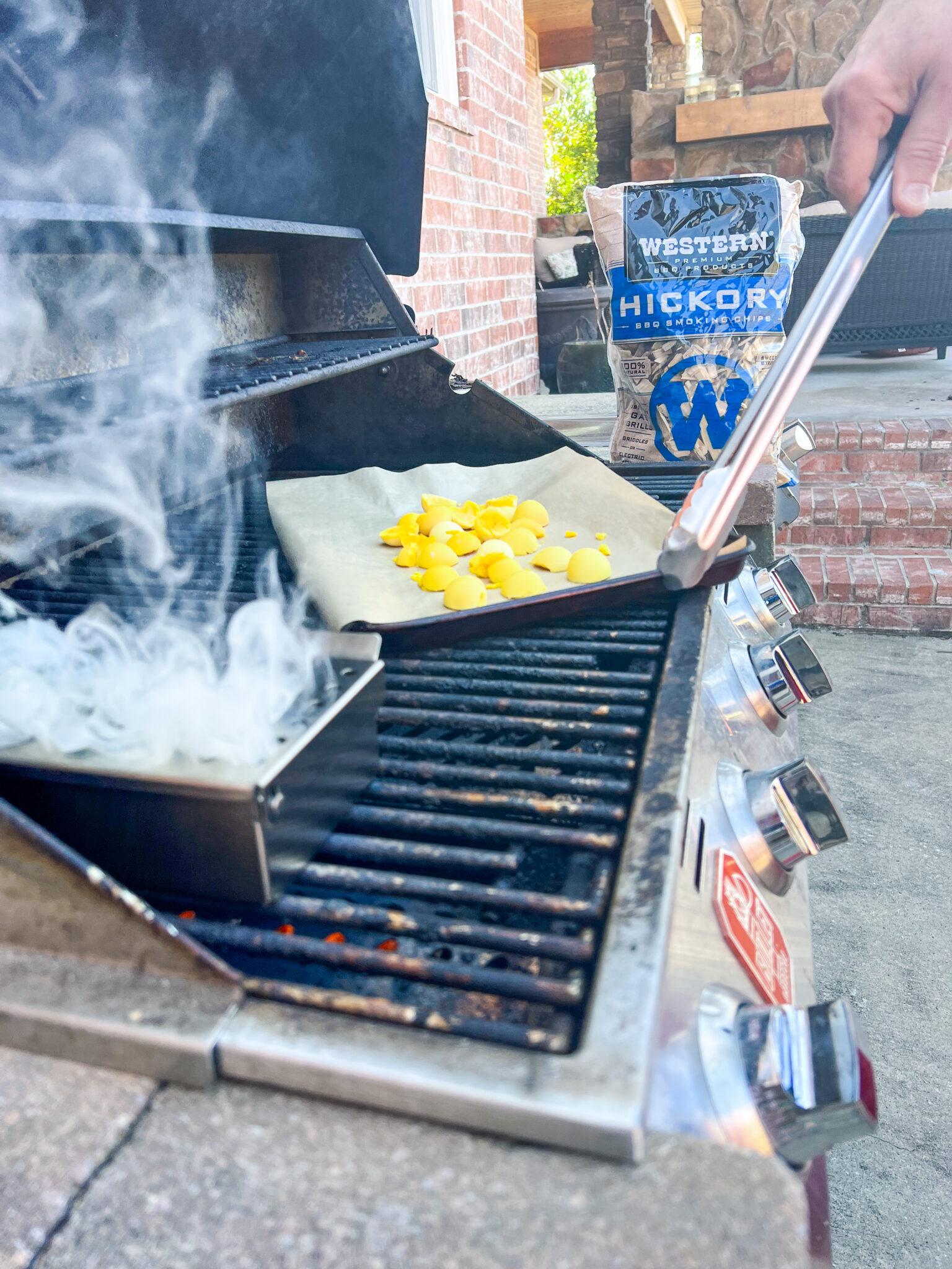 smoking hickory wood chips on a grill and cooked egg yolks on grill with bag of western bbq hickory chips in background