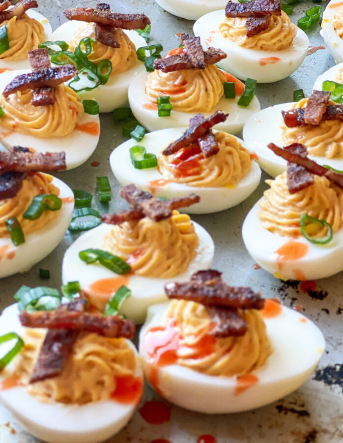 Smoked Deviled Eggs with Smoked Bacon Candy and Green onions and hot sauce