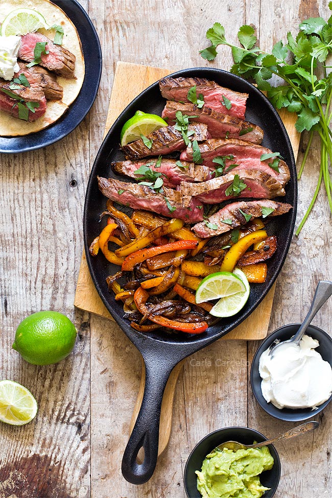 Steak fajitas for two on a pan with a lime and cheese