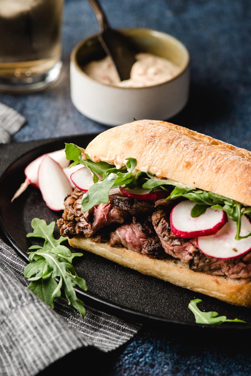Grilled Skirt Steak Sandwich with radishes on a plate with arugula