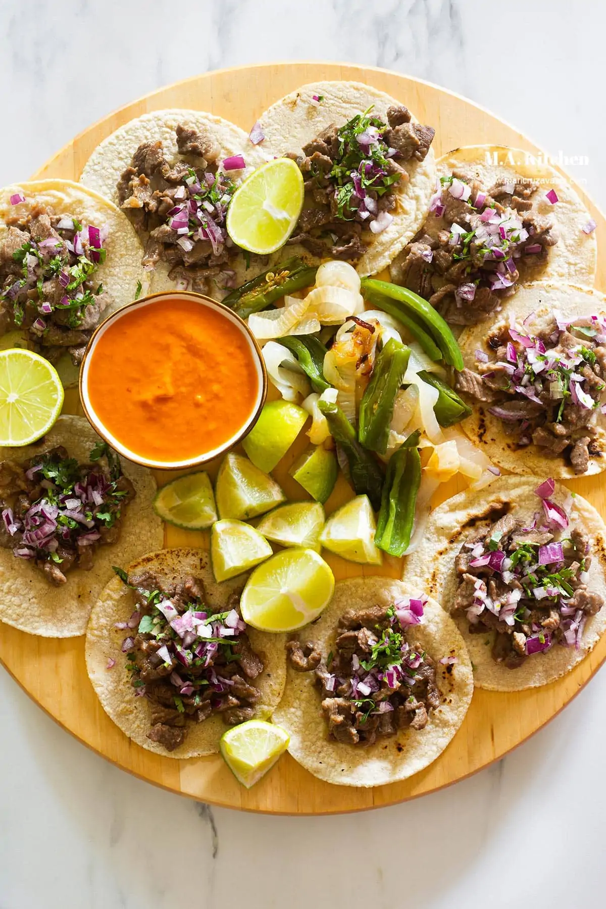 Authentic Tacos de Bistec tacos with sauce and limes and onions