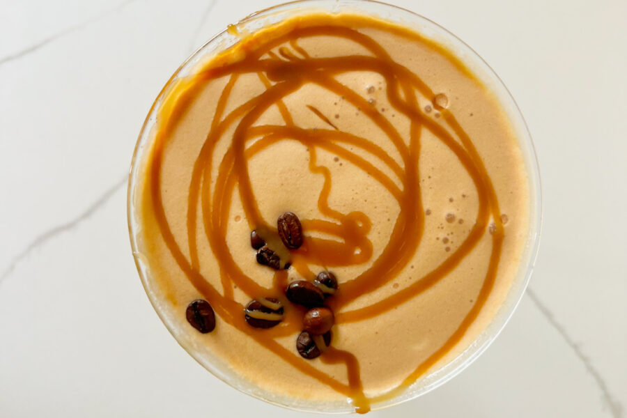 salted caramel fireball espresso martini with caramel drizzle and espresso beans on the top