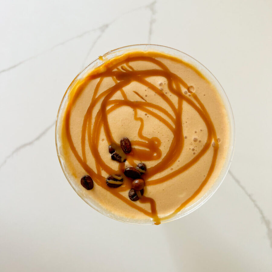 salted caramel fireball espresso martini with caramel drizzle and espresso beans on the top
