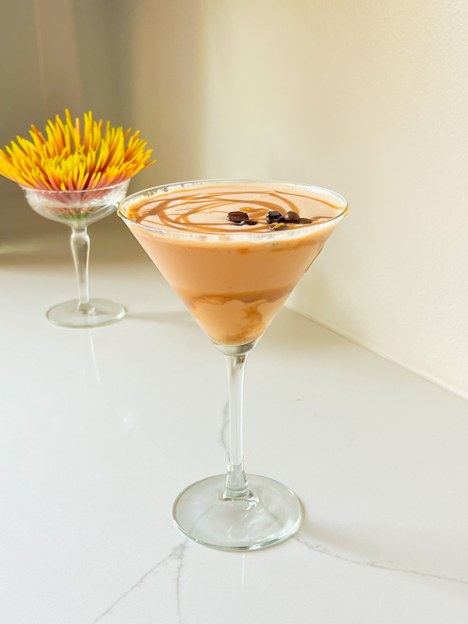 Salted Caramel Fireball Espresso Martini in a glass with a yellow and orange mum flower in a martini glass