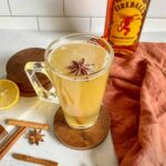 fireball hot toddy with star annice and cinnamon sticks and lemon and a bottle of fireball