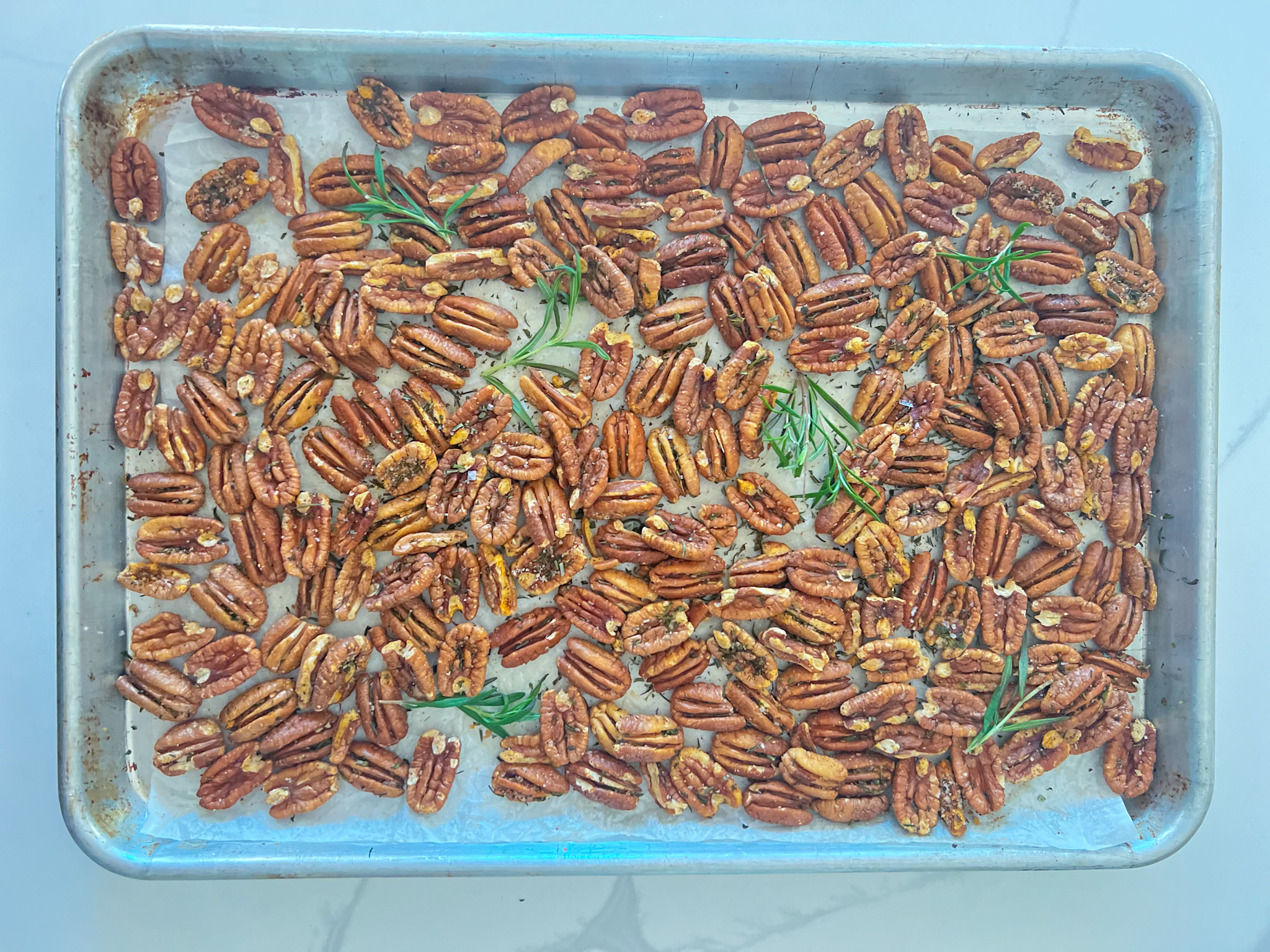 pearson farm pecans on a sheet pan with rosemary and seasoning