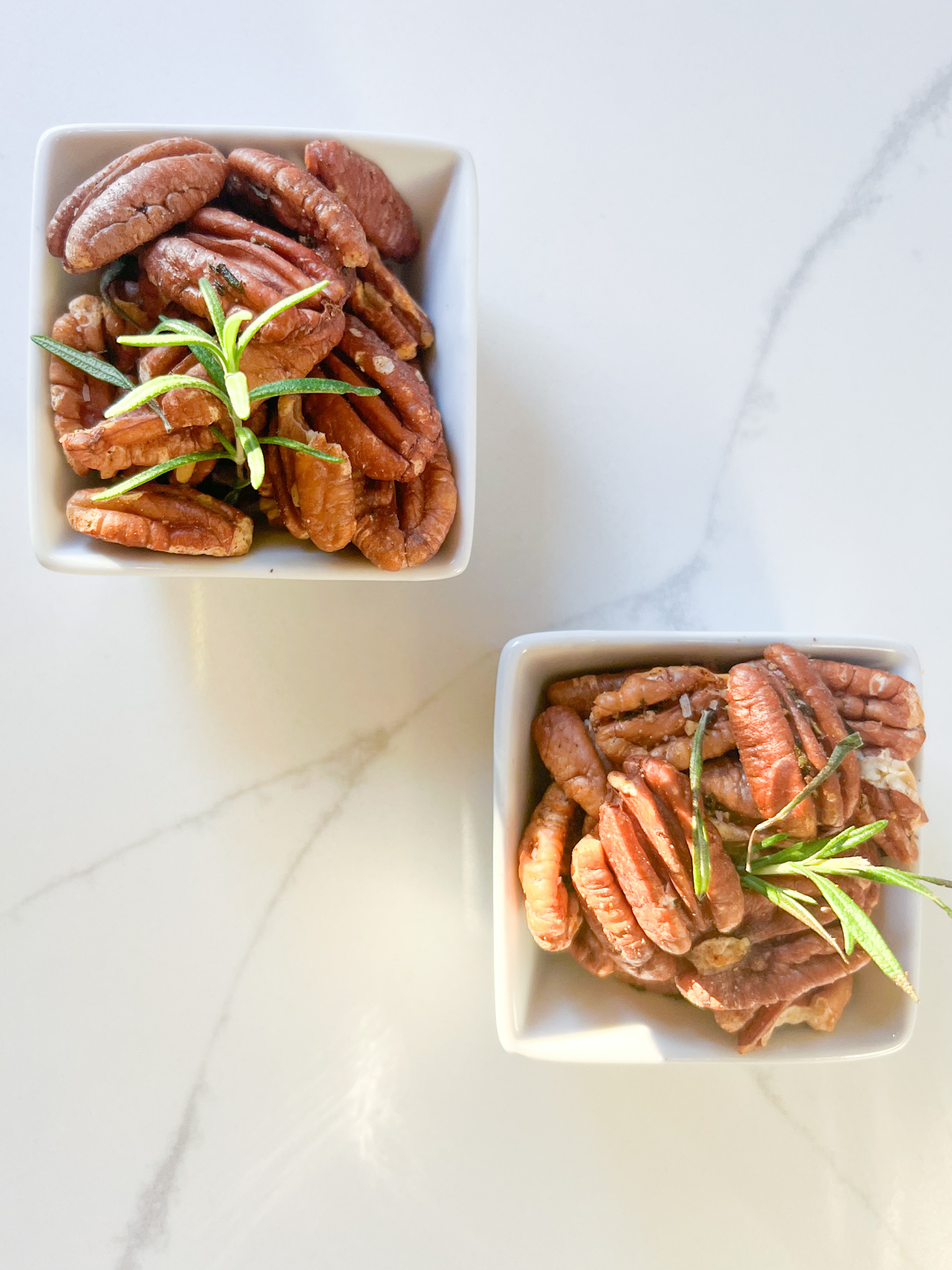 2 small square white bowls with roasted pecans recipe with rosemary