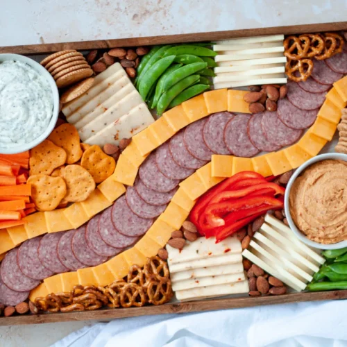 game day charcuterie board with meat and cheese and dips and veggies