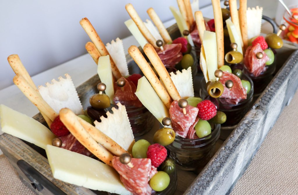 individual charcuterie jars with cheese, olives, meat and bread sticks