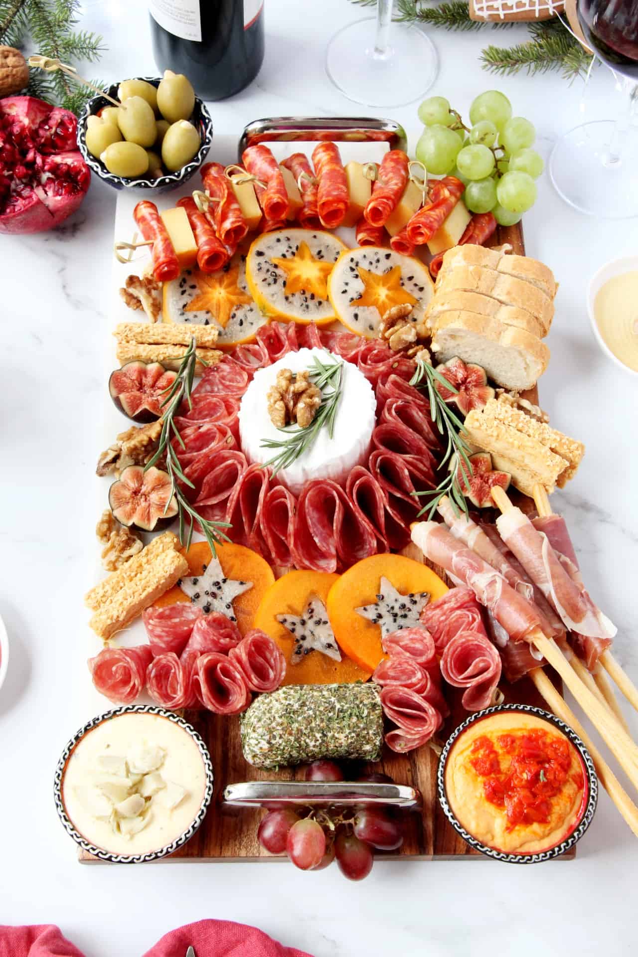Holiday Charcuterie board with a centerpiece of brie, lots of meats and cheeses.