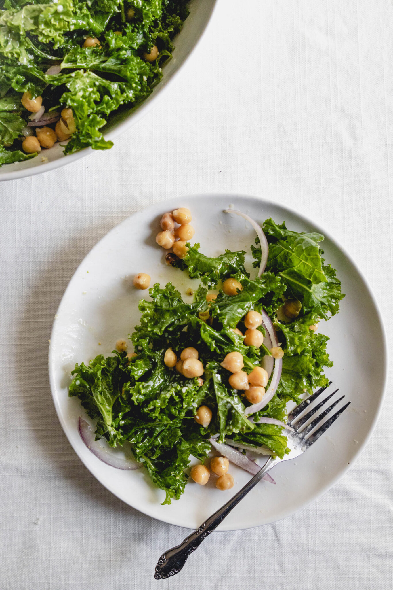 kale chickpea salad on a plate with a fork