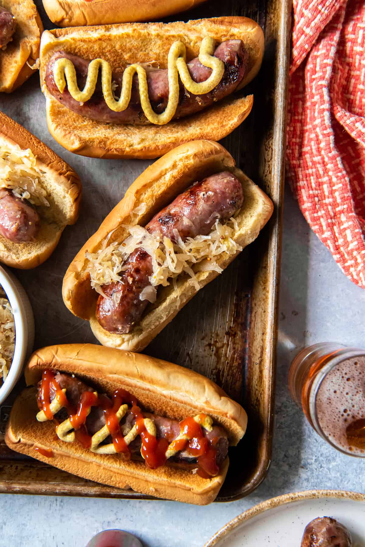 Beer Brats on a tray with mustard and toppings