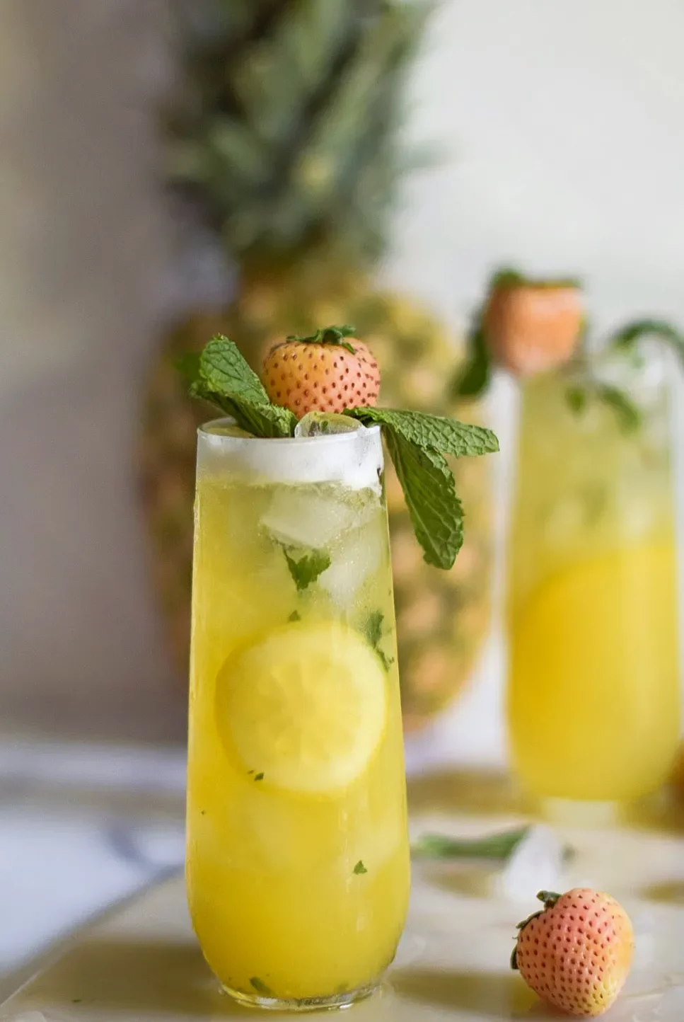 2 Pineberry-Pineapple Mint Coolers with a pineapple in the background