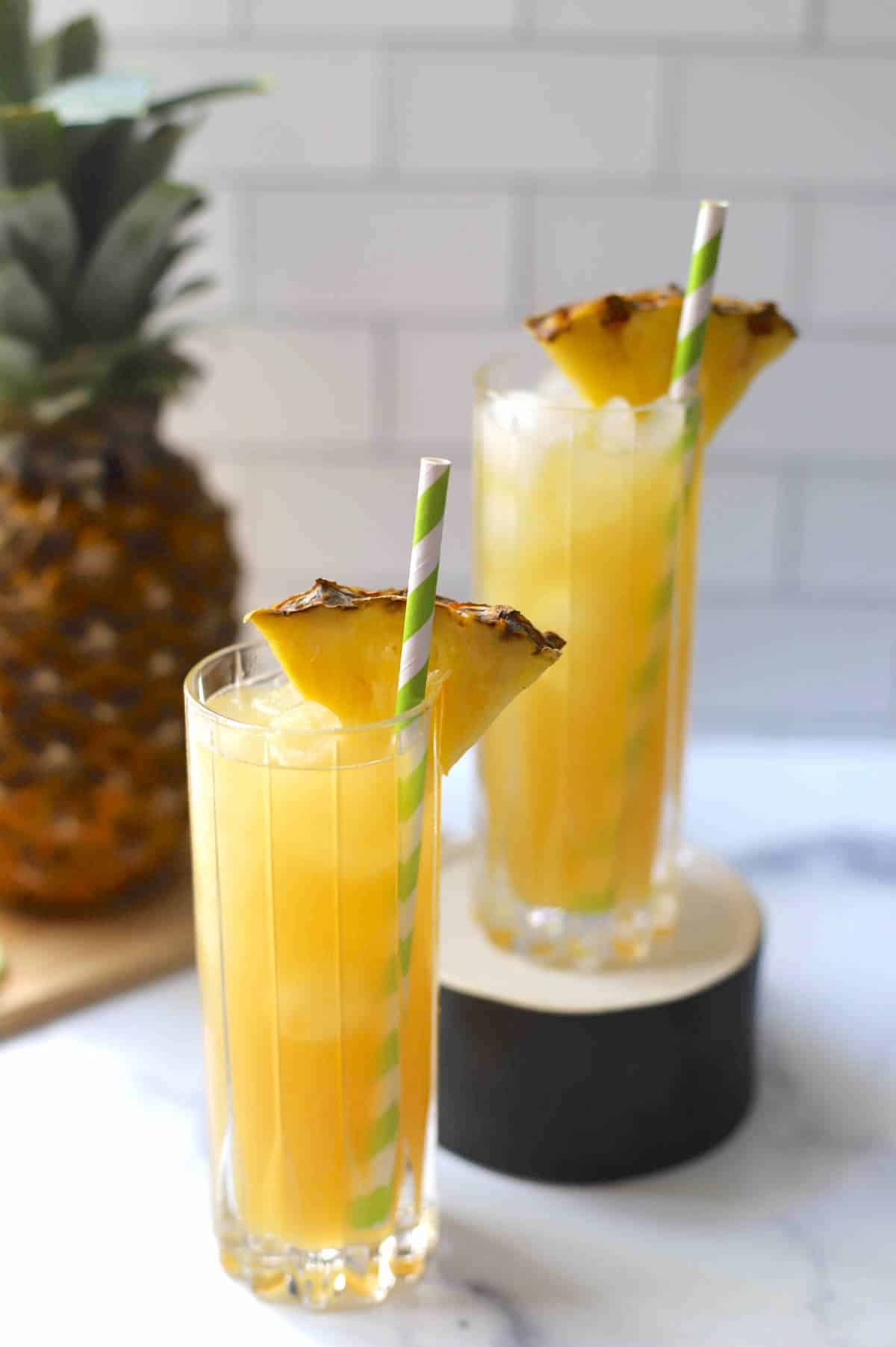 Goombay smash tropical cocktails in two glasses with pineapple wedges