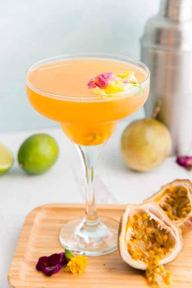 Passion fruit Daiquiri in a glass with limes and passion fruit