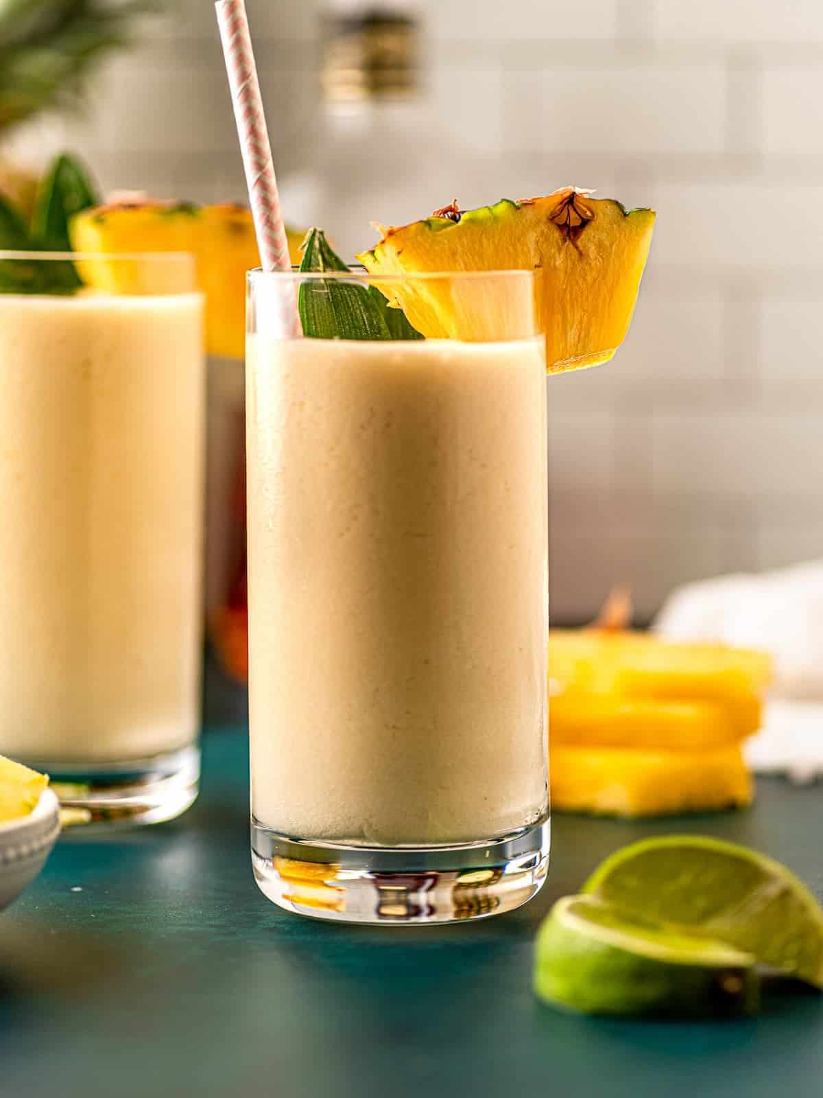 2 pina coladas with straws and pineapple